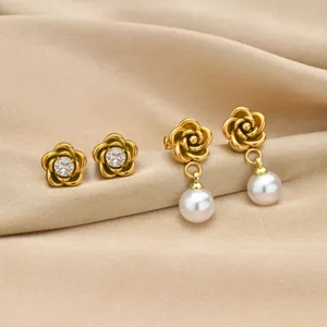 Detail of golden camellia flower earrings with pearls on champagne silk fabric