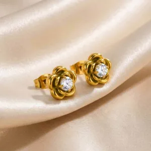 Macro detail of golden camellia flower earrings with sparkling central zircon stone