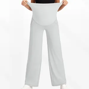 Gros plan sur la bande de soutien haute élasticité du pantalon de grossesse gris large