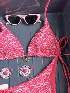 Close-up of pink bikini with white 3D flower embroidery and gold metal detail