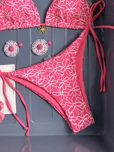 Detail of pink floral bikini with seersucker texture and gold flower pendant charm
