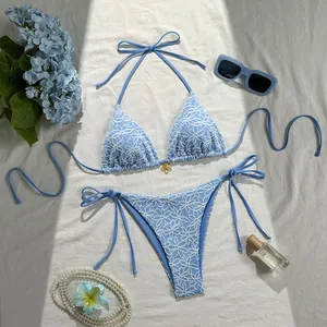 Light blue two-piece bikini set with white floral embroidery and gold flower detail