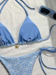 Detail of light blue bikini top with golden flower pendant and removable chest pads