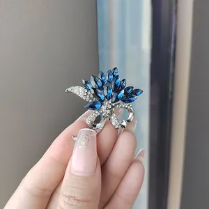 Gros plan sur la broche bouquet avec cristaux bleu marine et détails argent