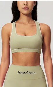 Close-up of moss green yoga set featuring white contrast stitching and U-neck sports bra