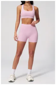 Detailed view of pink racerback sports bra and high-waisted shorts on fitness model