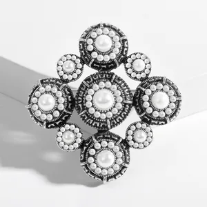 Detail of vintage Baroque pearl brooch with oxidized silver finish and floral embossing