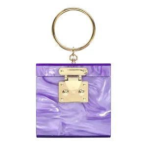Detail of purple marble acrylic clutch bag with gold round handle and lock