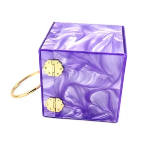 Detail of purple marble acrylic box bag with golden floral hinges and round handle