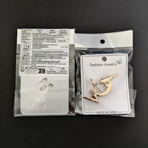 Detail of golden alloy microscope brooch with rhinestones in clear plastic packaging