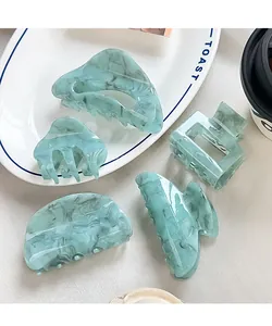 Detail view of light green marble texture hair claw clips set in various geometric shapes