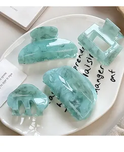 Detail of 4-piece light green marble acrylic hair claw clips set in decorative plate