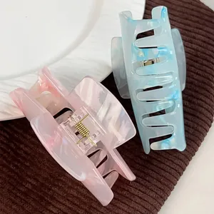 Large pink and blue acrylic hair claws with elegant marble texture and metal springs