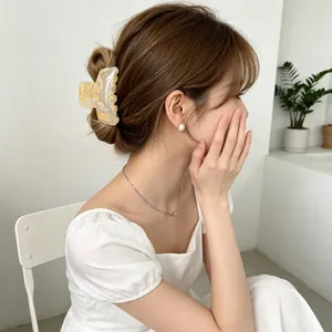 Cream marble acrylic hair claw clip for elegant bun hairstyles in minimalist style
