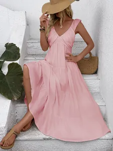 Detail of pink V-neck tiered maxi dress with wide shoulder straps in a resort setting