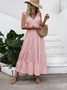 Detail of light pink V-neck dress with ruffled shoulders and layered tiered skirt