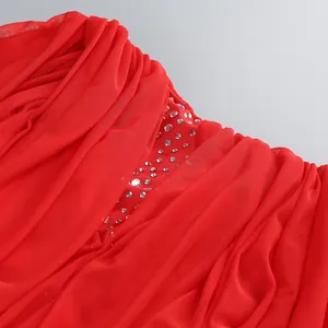 Close-up of red evening dress featuring elegant draping and shimmering silver rhinestones