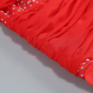 Detail of red mesh dress fabric with elegant pleats and sparkling rhinestone accents