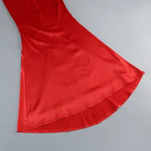 Detail of red satin dress hem with layered high-low cut and premium silk texture