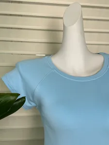 Detailed close-up of light blue ribbed knit t-shirt with crew neck and raglan sleeves
