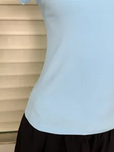 Detail view of light blue ribbed knit t-shirt showcasing slim fit waistline and fabric texture