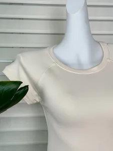Detailed view of cream raglan sleeve t-shirt in ribbed knit texture on a mannequin