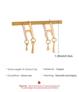 Detail shot of gold asymmetrical star moon earrings showing copper material and size specs