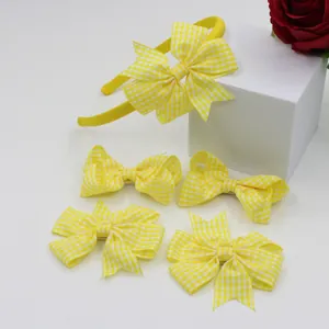 Detailed set of yellow gingham bow headbands and hair clips on minimalist stands