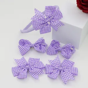 Detail of 5pcs set purple gingham bow headband and hair clips on a white display stand