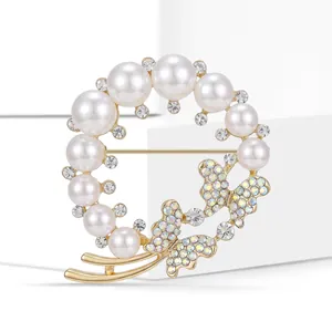 Détail de la broche couronne en perles avec papillons et strass brillants étincelants
