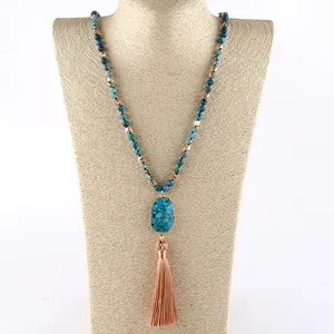 Detail of Bohemian beaded necklace featuring turquoise stone and light orange silk tassel