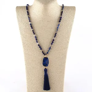 Detail of bohemian necklace featuring dark blue imperial stone and long silk tassel