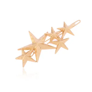 Détail macro de la pince à cheveux dorée à cinq étoiles montrant la finition mate