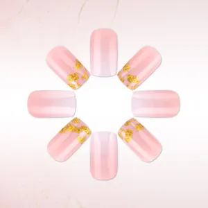 Detail of pink gradient press-on nails with gold foil flakes on marble background