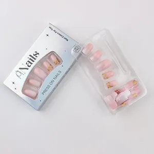 Detail of pink gradient press-on nails with gold foil flakes in product packaging
