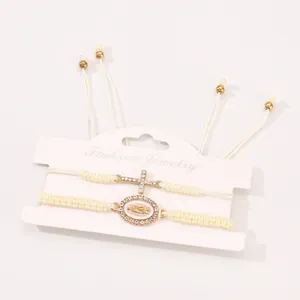 Detail of woven bracelets set with rhinestone cross and Virgin Mary metal charms