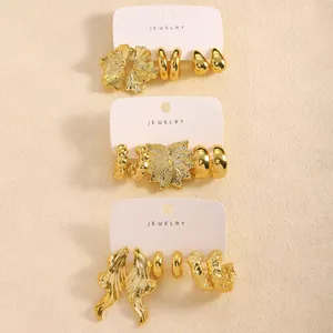 Detailansicht goldener geometrischer Ohrring-Sets mit floralen und Blatt-Texturen
