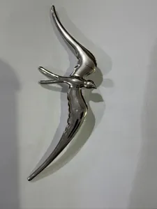 Gros plan détaillé d'une broche hirondelle en acier inoxydable argenté poli de luxe