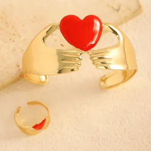 Detalle del conjunto de brazalete y anillo ajustable con manos sujetando un corazón