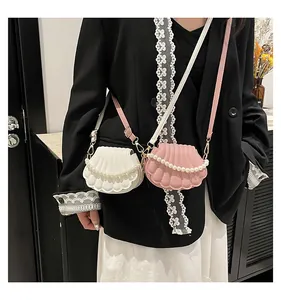 Détail du mini sac bandoulière coquillage avec anse en perles et cuir plissé élégant