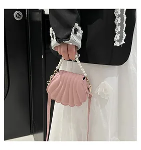 Détail du sac coquillage avec perles montrant le cuir PU rose et les ferrures métalliques dorées