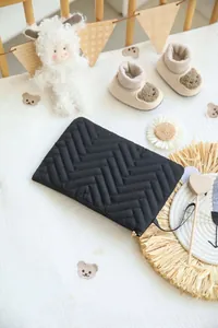 Macro shot of black quilted polyester pouch with V-stitch pattern and zipper detail