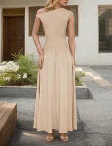 Detail of a beige one-shoulder maxi dress with elastic waist and flowing long skirt