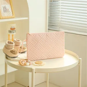 Quilted light pink travel cosmetic bag with wave pattern and portable handle strap