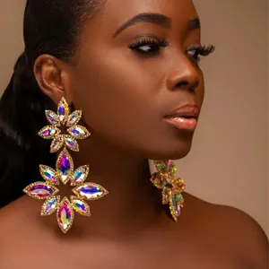 Dramatic gold floral drop earrings with marquise-cut iridescent rhinestones on model