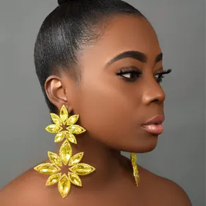 Exaggerated yellow crystal flower drop earrings on model with side profile view
