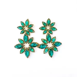 Macro shot of marquise-cut emerald green crystals on double floral drop earrings
