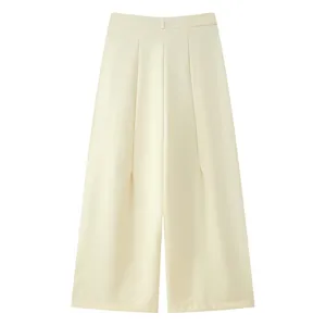 Detail view of high-waist cream wide-leg trousers with elegant pleats and draping fabric