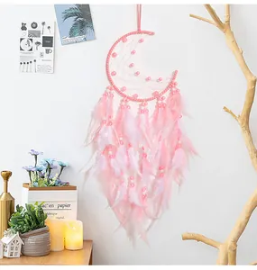 Close-up of pink moon dreamcatcher with soft feathers and beads for wall decor