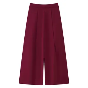 Close-up of wine red wide leg trousers featuring high waist and vertical pleated details